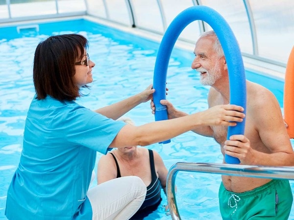 Imagen de personas mayores haciendo gimnasia acuática)